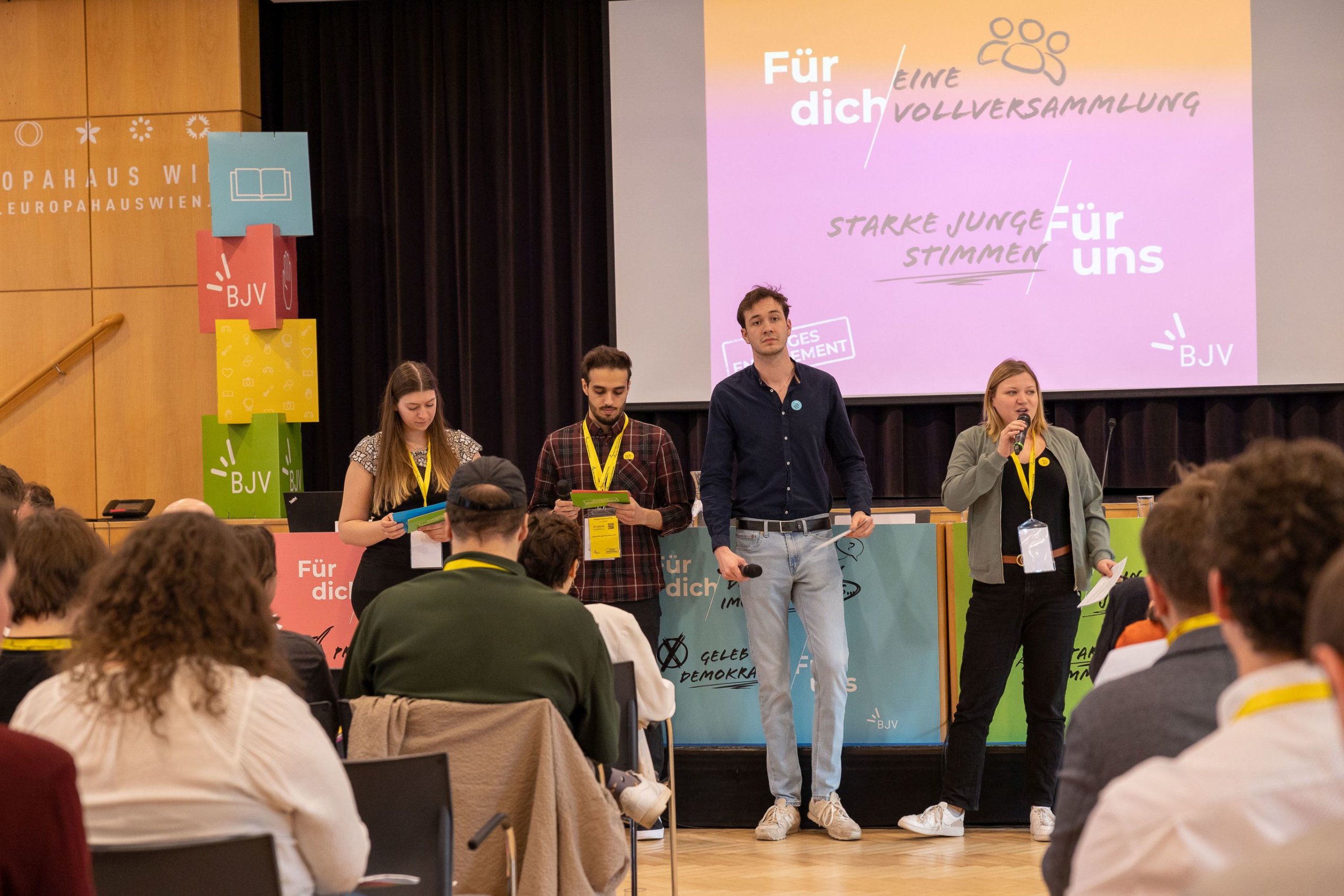 Das Vorsitzteam spricht vor den Delegierten im Saal der Vollversammlung