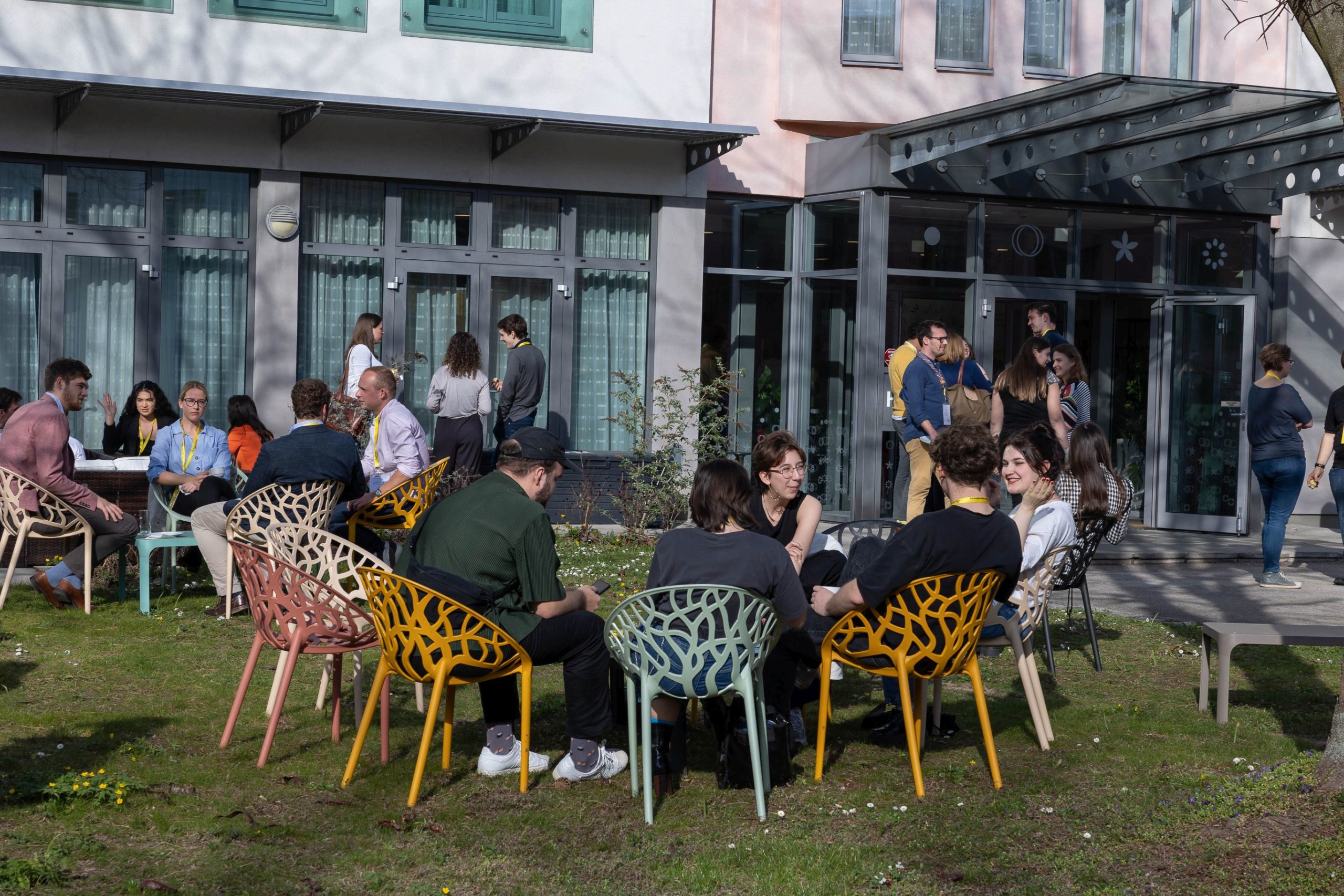 Teilnehmer*innen sitzen an Tischen im Garten