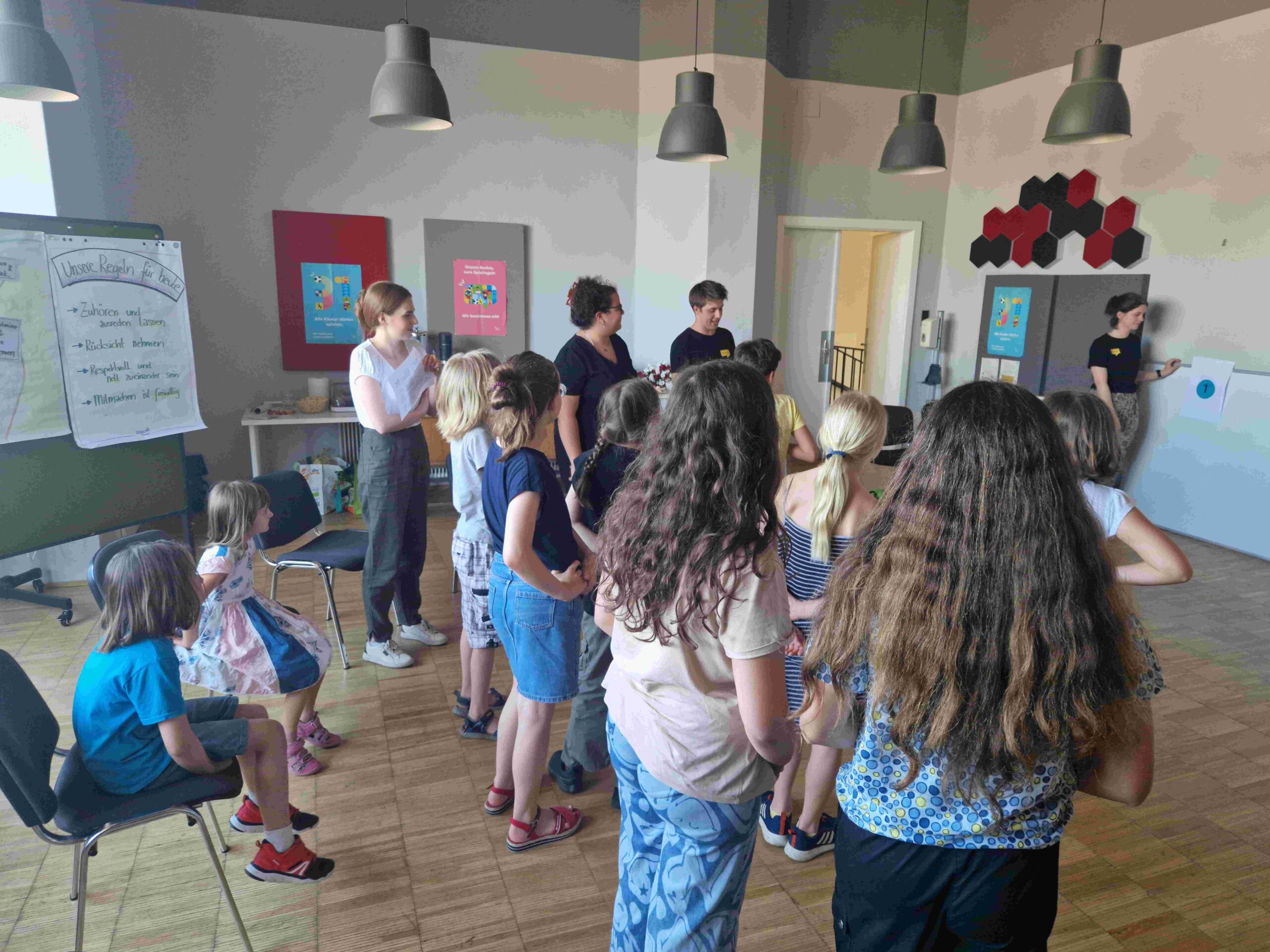 BJV-Vorsitzende Rihab und die BJV-Vorstandsmitglieder Julius und Magdalena beim Aufwärmspiel mit den Kindern des Kinderbeirats
