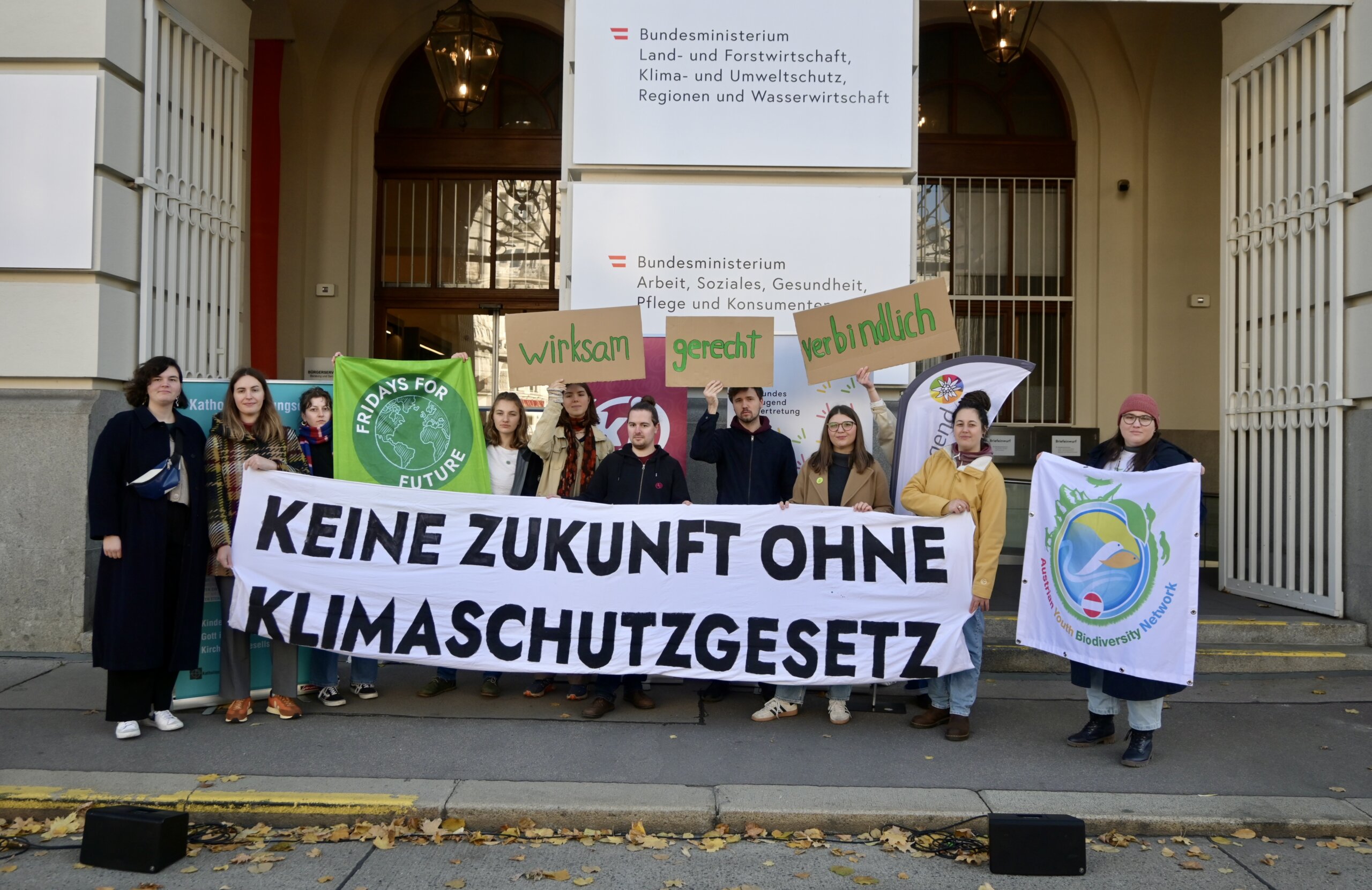 Vertreter*innen von Kinder- und Jugendorganisationen und der BJV stehen vor dem Klimaministerium und halten ein Banner.